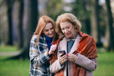 Büyükannesine cep telefonu kullanmayı öğreten bir torun..