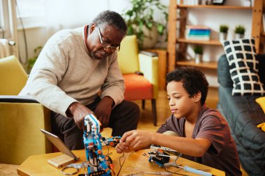 Bir büyükbaba ve torunu evde bir robot yapıyorlar..