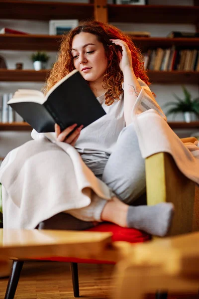 Beautiful Ginger Girl Sitting Living Room Wrapped Blanket Reading Interesting — Stock Photo, Image