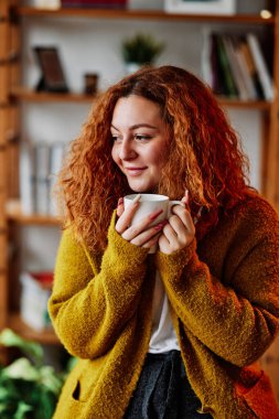 Rahat bir kızıl kızın portresi. Rahat evinde sabah kahvesinin tadını çıkarıyor..
