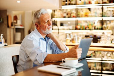 Bir son sınıf öğrencisi evde oturuyor ve boynunu okşuyor. Oturup ders çalışmaktan yoruldu..
