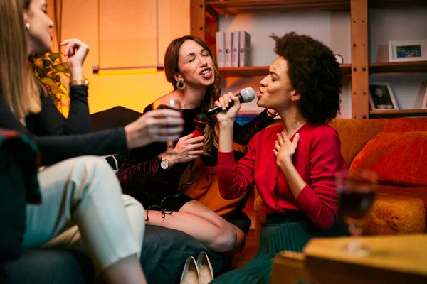 Δύο Πολυπολιτισμικές Νεαρές Γυναίκες Διασκεδάζουν Ένα Πάρτι Στο Σπίτι Τραγουδώντας — Φωτογραφία Αρχείου