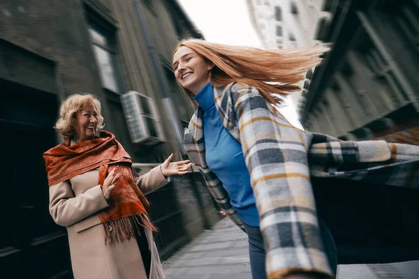 Neşeli bir torun sokakta büyükannesi için dans eder..