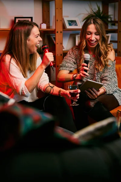 Δύο Όμορφες Νεαρές Γυναίκες Τραγουδούν Καραόκε Ένα Πάρτι Στο Σπίτι — Φωτογραφία Αρχείου