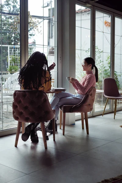 Dos Jóvenes Mujeres Multiculturales Están Sentadas Junto Ventana Café Tomando — Foto de Stock