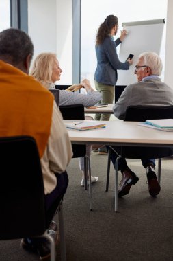 Son sınıf öğrencilerinden oluşan çok ırklı bir grup, sınıftaki genç bir eğitimciyle yeniden eğitim kursu veriyor..