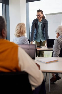 Neşeli bir hipster eğitmeni, son sınıf öğrencilerinden oluşan çok kültürlü bir gruba sınıfta proje yazmayı öğretiyor..
