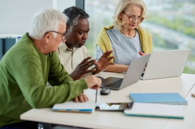 Son sınıf öğrencilerinden oluşan çok kültürlü bir grup sınıftaki dizüstü bilgisayarlarla ilgili bir proje yapıyor..
