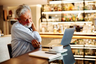 Son sınıf öğrencisi bir kafede oturuyor ve sırtı ağrıyor..