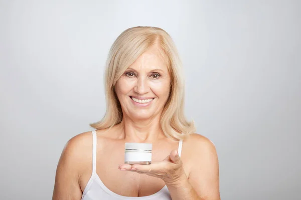 Una Mujer Rubia Mayor Feliz Sosteniendo Crema Edad Mano Mirando —  Fotos de Stock