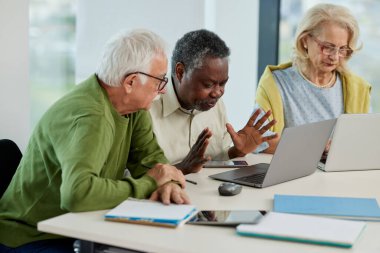 Son sınıf öğrencileri sınıfta dizüstü bilgisayarla proje üzerinde çalışıyorlar..