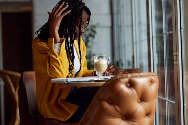 Çok kültürlü bir kız öğrenci ödev yazar ve çalışır..