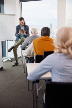 Genç bir eğitimci sınıftaki son sınıf öğrencilerinden oluşan çok kültürlü bir gruba ders veriyor..