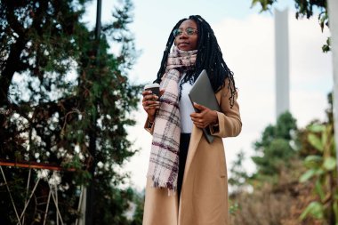 Kafenin önünde elinde bir bilgisayarla elinde kahveyle dolaşan bir serbest çalışan var..