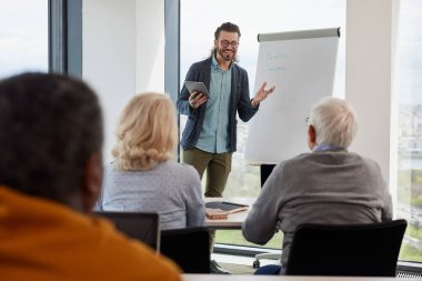 Genç bir eğitimci sınıftaki son sınıf öğrencilerinden oluşan çok kültürlü bir gruba ders veriyor..