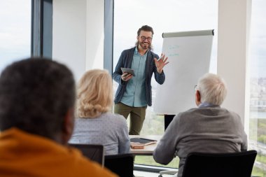 Genç hippi eğitimci, son sınıf öğrencilerinden oluşan çok kültürlü bir gruba sınıfta interneti nasıl kullanacaklarını öğretiyor..