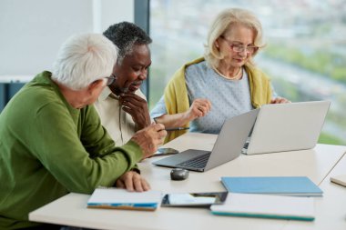 Son sınıf öğrencileri sınıfta dizüstü bilgisayarla proje üzerinde çalışıyorlar..