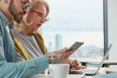 Bir eğitimci, son sınıf öğrencisinin materyallerde ustalaşmasına yardım ediyor..