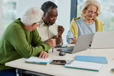 Son sınıf öğrencileri sınıfta dizüstü bilgisayarla proje üzerinde çalışıyorlar..
