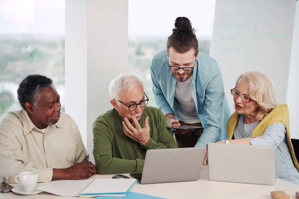 Genç bir hippi öğretmen, bir grup son sınıf öğrencisine dizüstü bilgisayarları ve teknolojiyi anlatıyor..