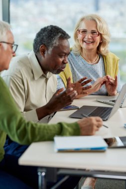 Çok kültürlü son sınıf öğrencilerinden oluşan küçük bir grup sınıfta oturup okul projesi üzerinde çalışıyorlar..