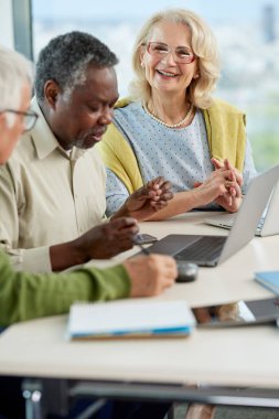 Çok ırklı son sınıf öğrencilerinden oluşan küçük bir grup dizüstü bilgisayardaki okul projesini bitiriyor..