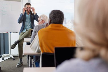 Neşeli bir hipster eğitmeni, son sınıf öğrencilerinden oluşan çok kültürlü bir gruba sınıfta proje yazmayı öğretiyor..