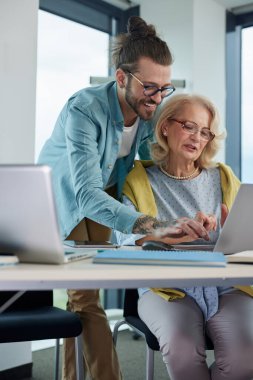 Bir eğitimci, son sınıf öğrencisinin materyallerde ustalaşmasına yardım ediyor..