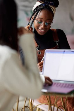 Kafeteryada oturan ve sınava çalışan iki çok kültürlü kız öğrenci..