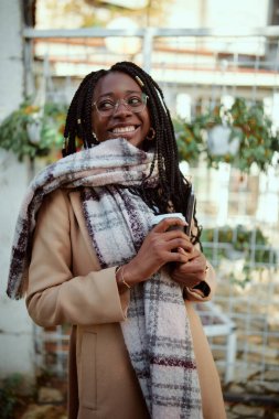 Kafenin önünde elinde bir bilgisayarla elinde kahveyle dolaşan bir serbest çalışan var..