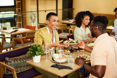 Çok kültürlü bir arkadaş grubu restoranda yemek yiyor..