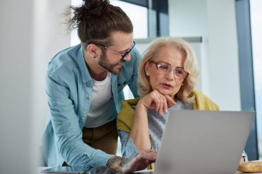 Bir eğitimci, son sınıf öğrencisinin materyallerde ustalaşmasına yardım ediyor..