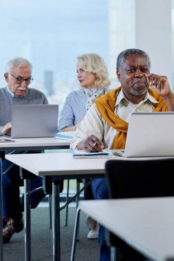 Son sınıflar bir sınıfta oturup dizüstü bilgisayardaki projeden bahsederken çok kültürlü bir son sınıf öğrencisi önplanda sorular soruyor..