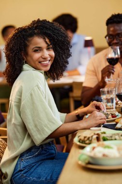 Mutlu bir İspanyol kız, erkek arkadaşıyla bir restoranda oturup yemek yer..