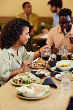 Mutlu bir İspanyol kız, erkek arkadaşıyla bir restoranda oturup yemek yer..