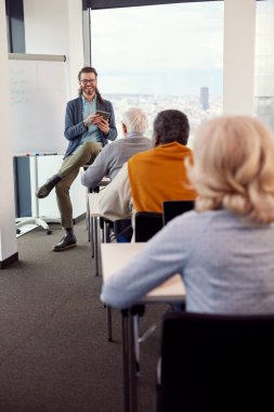 Sınıfta çok ırklı bir grup yaşlı öğrenci için kurs veren genç bir hippi eğitmen..