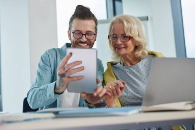 Bir eğitimci, son sınıf öğrencisinin materyallerde ustalaşmasına yardım ediyor..