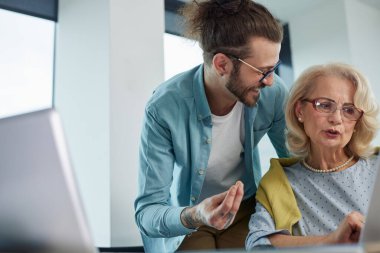 Bir eğitimci, son sınıf öğrencisinin materyallerde ustalaşmasına yardım ediyor..