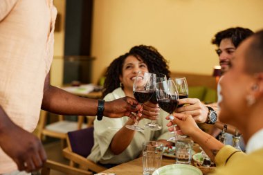 Irklar arası arkadaşlar kırmızı şaraplı bir restoranda başarı için kadeh kaldırıyorlar..