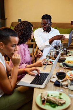 İş adamları bir restoranda yemek masasında oturup bir başlangıç projesi hakkında beyin fırtınası yapıyorlar..