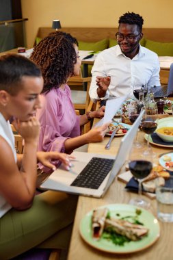 Bir grup ırklar arası meslektaşın restoranda iş yemeği var..