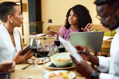 Bir grup ırklar arası meslektaşın restoranda iş yemeği var..