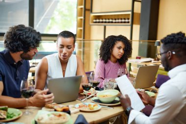Corporate workers having casual business meeting in a restaurant during lunch.