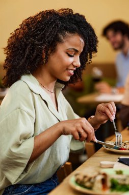 İspanyol bir kız restoranda oturmuş yemek yiyor..