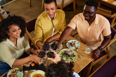 Top view of a group of friends celebrating a happy event during a dinner party in a restaurant.