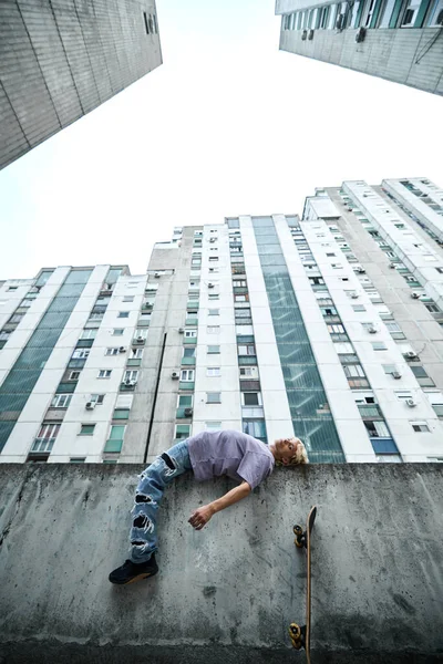 Teenage Boy Lying Concrete Wall Surrounded Buildings — Fotografia de Stock