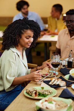 A hungry Hispanic girl is eating dinner at the restaurant.