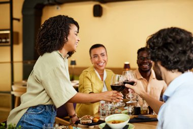 Friends are toasting with red wine in a restaurant during the dinner.