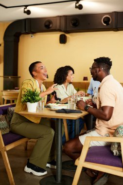 A group of cheerful friends are eating dinner in a restaurant.