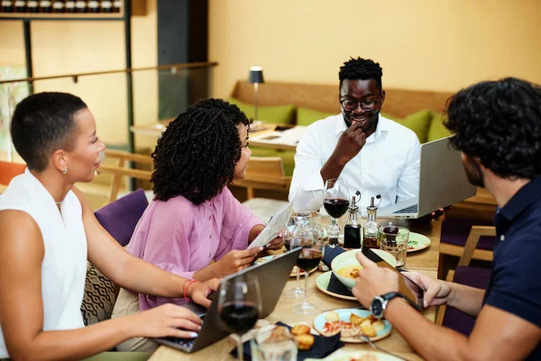 Happy businesspeople have a briefing in a restaurant during business lunch.